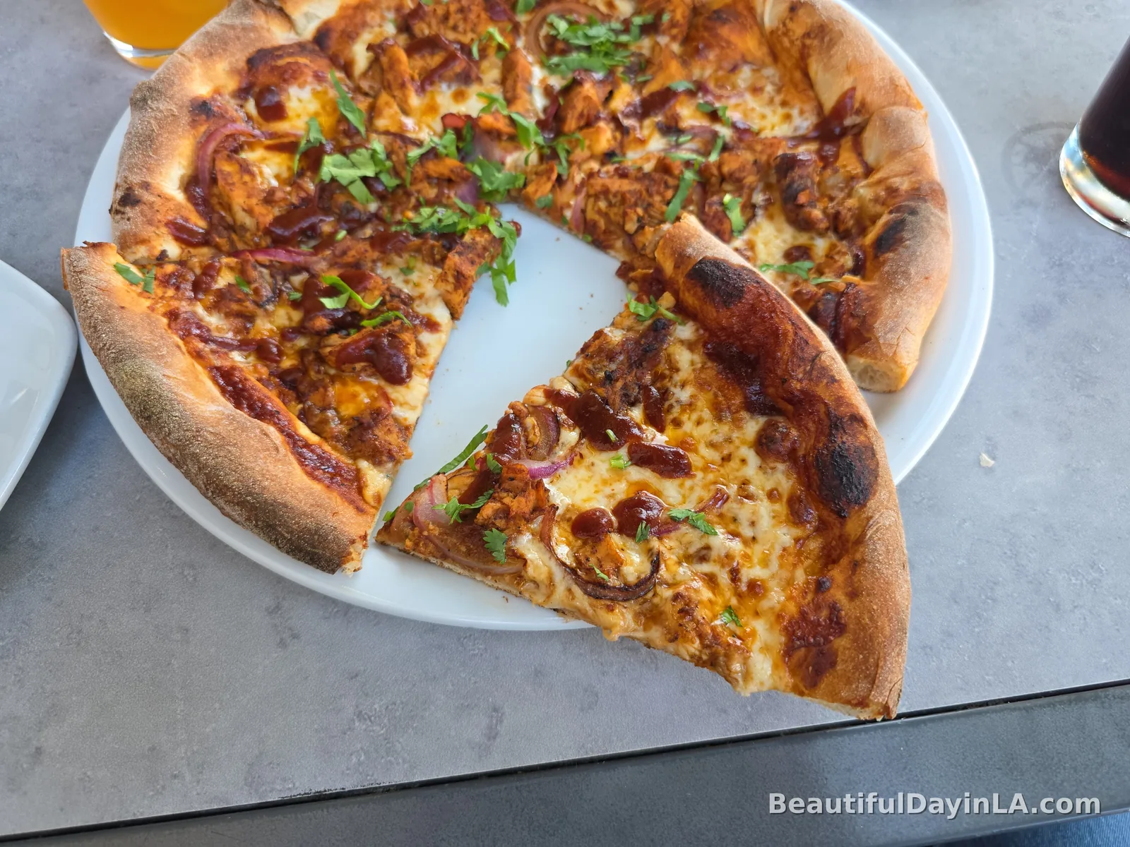Close-up of a slice of BBQ Chicken Pizza showing crispy crust and toppings